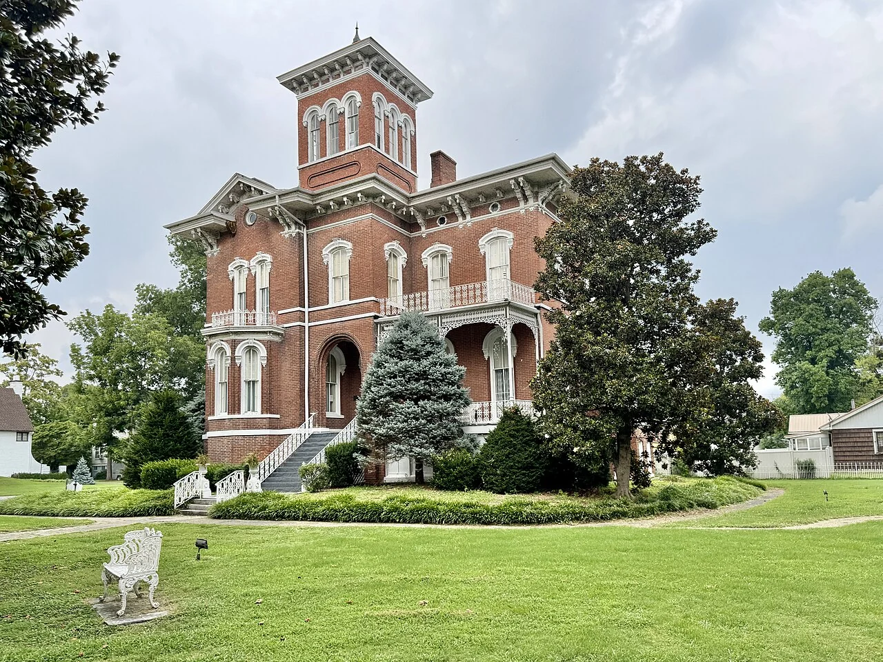 Magnolia Manor’s red brick tower, ornate white trim, and garden in Cairo.
