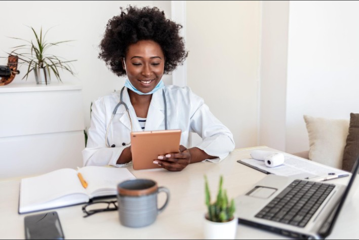 A clinician reviewing information on a tablet at her desk